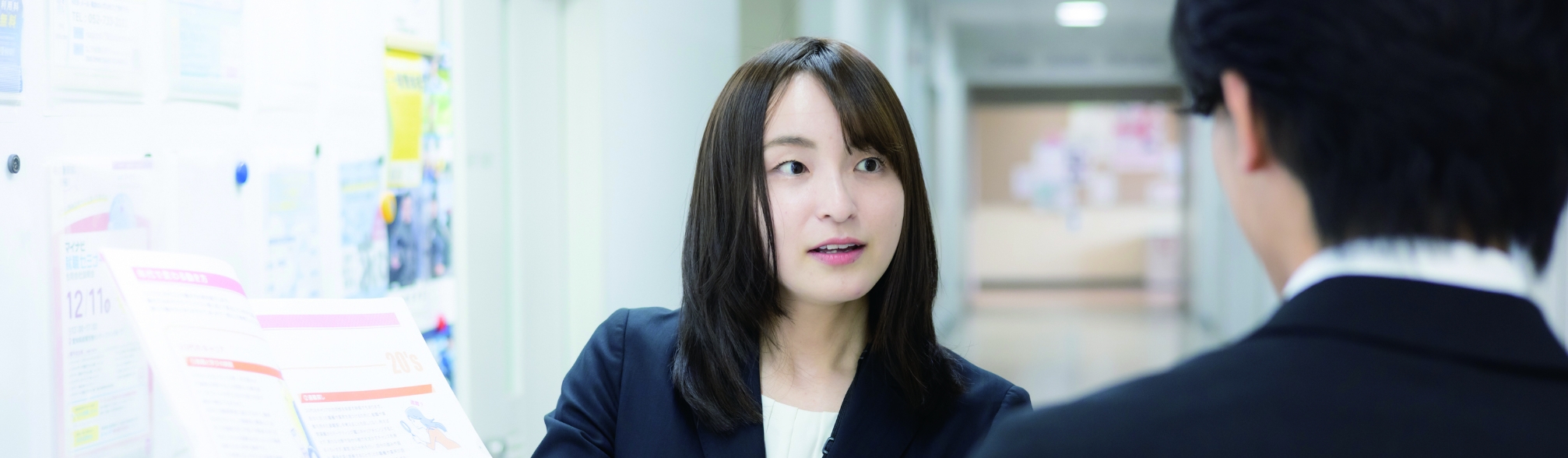 大学で説明資料をもとに話をするキャリア支援担当者と学生。