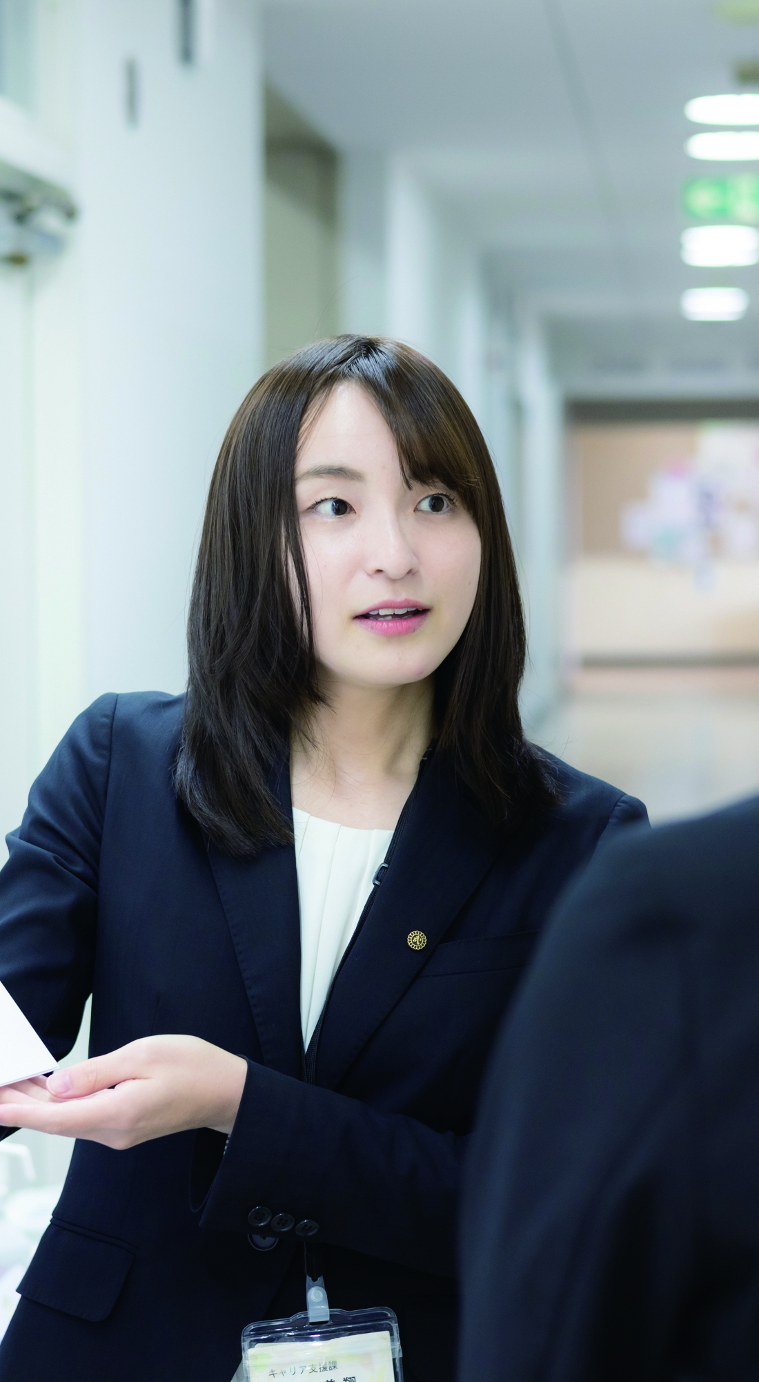 大学で説明資料をもとに話をするキャリア支援担当者と学生。